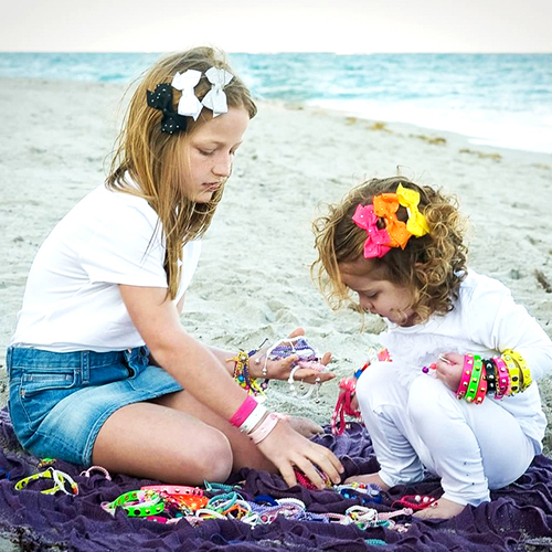 Stylish girls play with Animal Crackers accessories on the beach