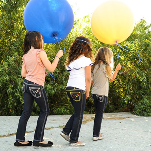 Stylish girls play with balloons while wearing clothing from Animal Crackers boutique